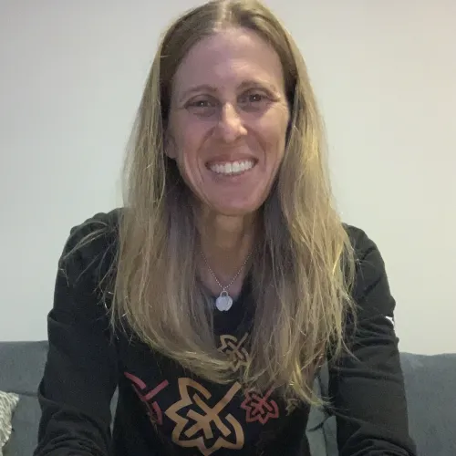 a woman smiling in front of a red wall