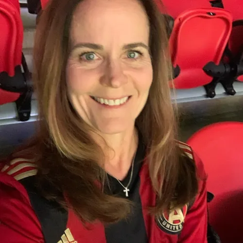 a woman smiling in front of a red wall