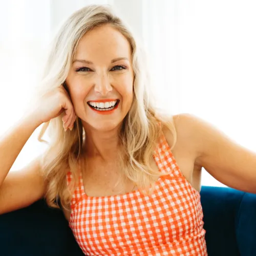 a woman smiling and wearing a red and white dress